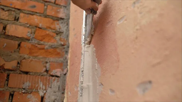 hand of builder worker use trowel plastering concrete at wall. The use of mortar for wall repairs.