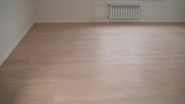 New laminate in a new apartment. empty room after renovation- two windows, white walls and wooden floor in new apartment — Stock Footage New Laminate New Apartment Empty Room Renovation Two Windows White Stock Footage