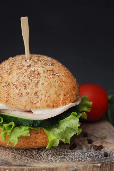 Fast Food, ahşap masa ve siyah arka plan üzerinde domates ile ev yapımı hamburger. Dikey görüntü.