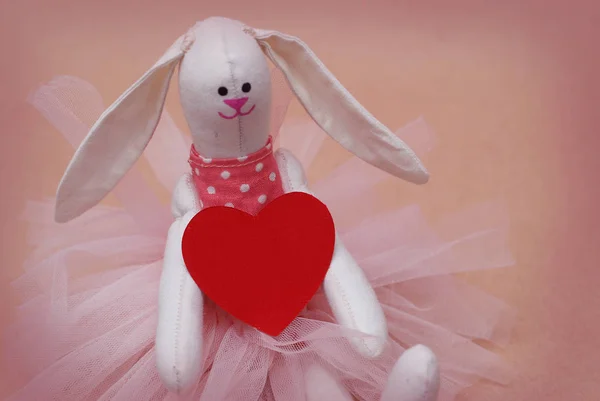 Toy Bunny with Red Heart Holding. Postcard to Valentine's Day. Mother's Day. Pink Background. — Stock Photo, Image