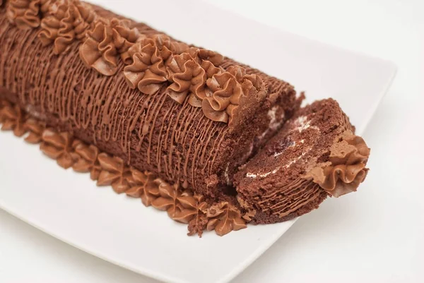 Десерт їжі ізольовані. Шоколадний торт на білий довгий пластини. Вид зверху. Нарізаний Darck пиріг з кремом. — стокове фото