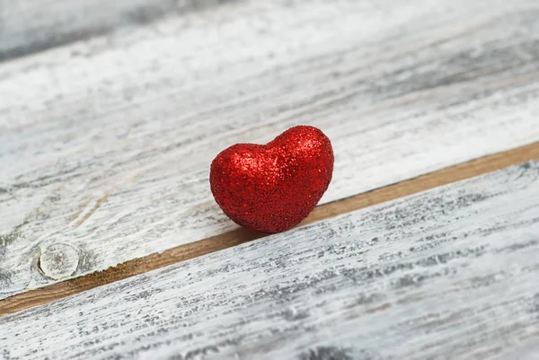 El corazón rojo brillante se encuentra en la grieta del fondo de madera. La separación, la soledad, el amor, la añada. Día de San Valentín . — Foto de Stock