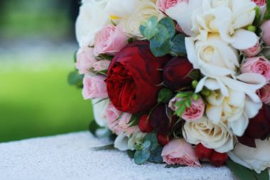 Gelin buketi. Düğün buketi. Bir buket kırmızı ve pembe ve kırmızı güller ve arka plan bulanık Peonnies çiçekler.