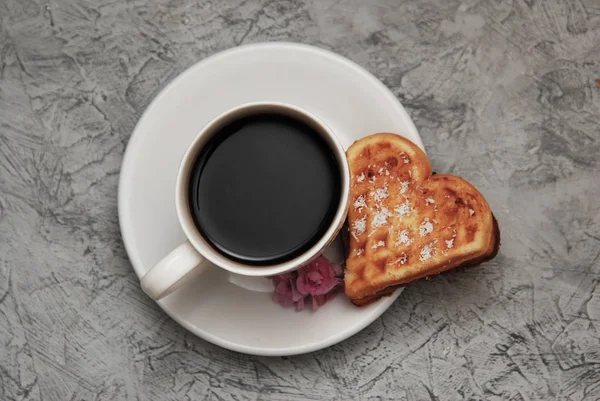 Waffelkekse in Herzform mit Tasse Kaffee auf Holzhintergrund zum Valentinstag, von oben — Stockfoto