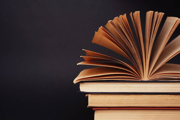 Open Book on a raw of Books close-up on a Dark background of school board with Copy Paste