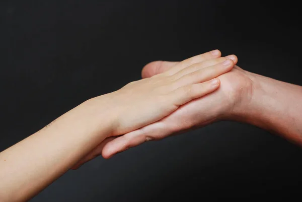 Vader Hand geven aan een kind. Ouderlijke Relationshipp, close-up. Isoalted op zwarte achtergrond. — Stockfoto