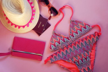Yaz aksesuarları, Straw hat ile pembe kurdele, Mayo, güneş gözlüğü, pasaport, pembe bir arka plan üzerinde. Seyahat. Holliday.
