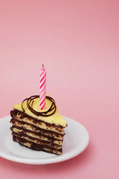 Csokoládé torta rózsaszín háttér, a gyertyát, és másolás helyet. Függőleges kép. — Stock Fotó