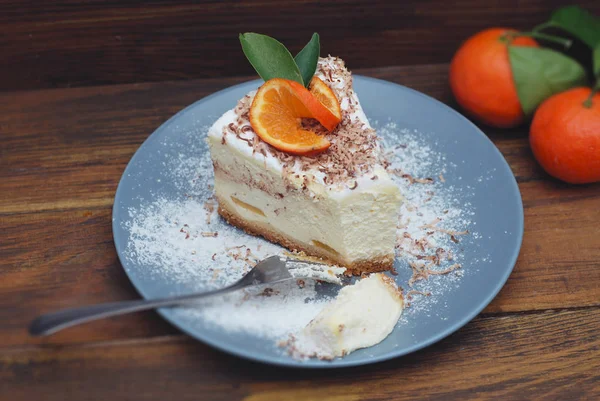 Festa di compleanno Pezzo di torta di formaggio fatta in casa con mandarini su piatto grigio su sfondo di legno. Vista dall'alto . — Foto Stock
