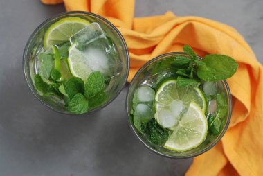 Mohito alkol içki. İki kadeh kokteyl içki ve buz küpleri ve limes narenciye meyve ile.
