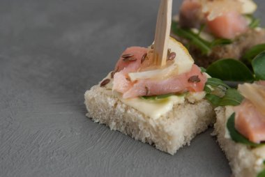 Roka yaprakları ile Somon kanepe tereyağı krem ve beyaz ekmek. Sağlıklı Snack. Gri arka plan. kopyalama alanı.