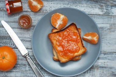Taze tost ile ev yapımı turuncu gri plaka üzerinde ahşap arka plan üzerinde reçel..