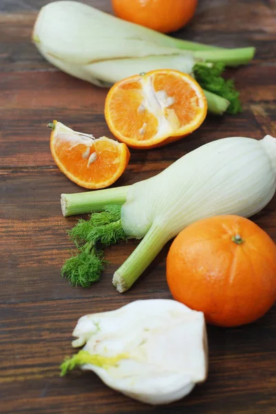 Édeskömény növényi, elszigetelt. Édeskömény és narancs citrusfélék felett fa háttér. Egészséges vegetáriánus ételek. — Stock Fotó
