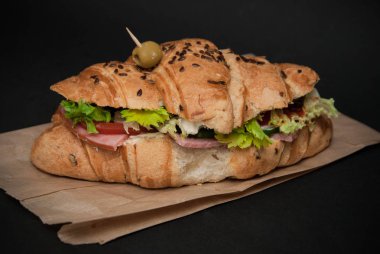 Peynir, marul ve domates Craft yetkin ve siyah arka plan üzerinde kruvasan sandviç. Sağlıklı snack. Yukarıdan görüntülemek.