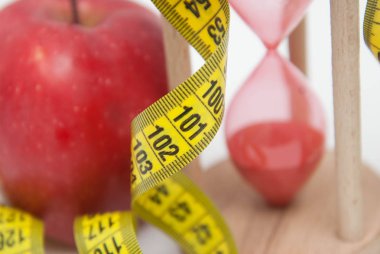 Ağırlık kavramı kaybetmek. Kırmızı elma ve şerit metre yakın çekim. Yağ yakıcı ve ağırlık kaybı süreci.