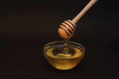 Koyu arka plan izole kopya alanı ile üzerine kepçe ile cam kapta tatlım.