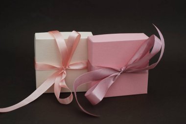 İki hediye kutuları ile bir pembe kahverengi zemin üzerine Isolated yay. Hediye, doğum günü. Satılık kavramı. Kopya alanı metin için.