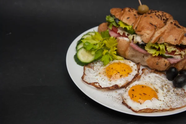 튀긴 계란과 샌드위치 크로 복사 텍스트 위한 공간와 검은 배경에 화이트 접시에. — 스톡 사진