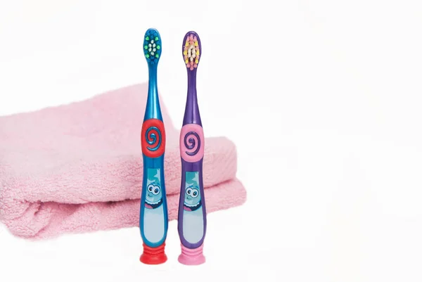 Renk diş fırçaları için izole çocuklar kopya alanı ile pembe havlu ile beyaz arka plan üzerinde. — Stok fotoğraf