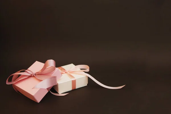 两个礼品盒, 粉红色的弓被隔离在棕色背景。礼物生日销售理念。复制文本空间. — 图库照片