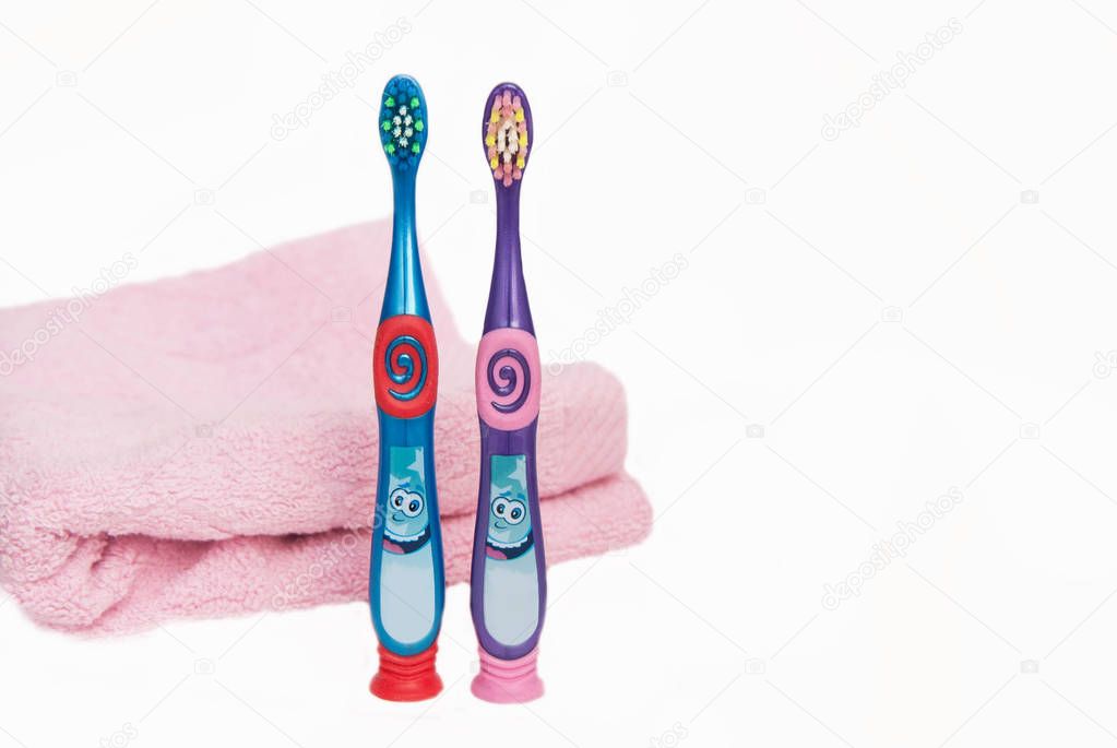 Color Toothbrushes for Kids Isolated on white background with Pink Towel with copy space.
