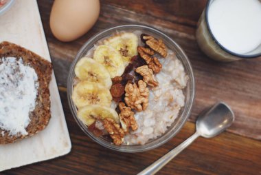 Granola kase, müsli yulaf, fındık ve kuru meyve, süt, ile ile ahşap masaya Servis Kahvaltı. Bannana, fındık, meyve. Sağlıklı kahvaltı. Diyet.
