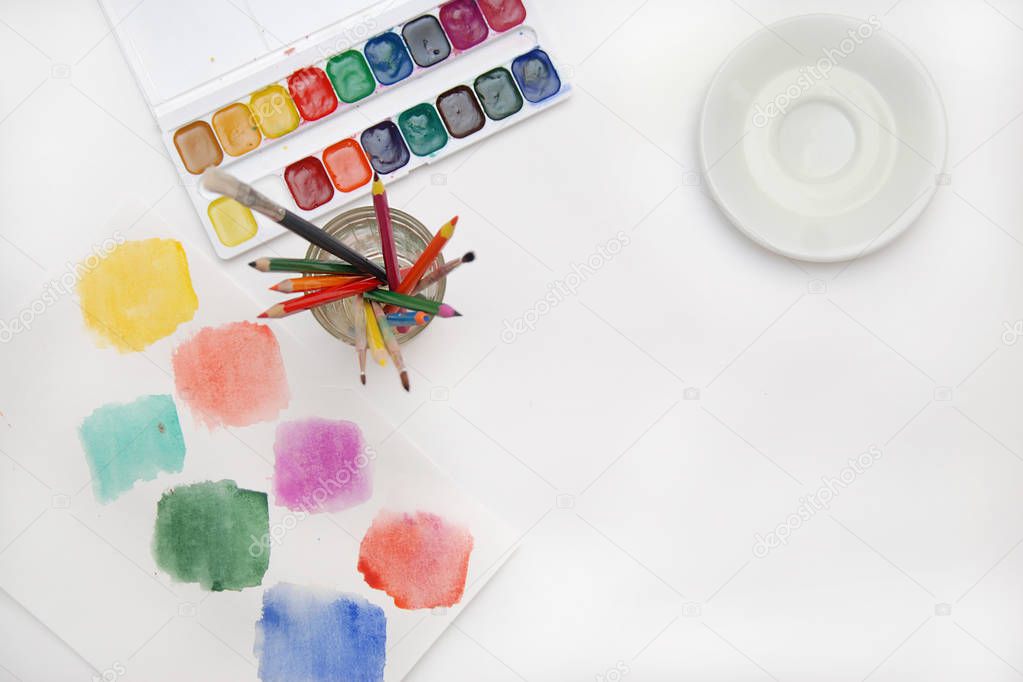 Top view of Work Process Blank Watercolor Paper pad, Watercolor Painting Supplies, Brushes and Colorful Pencil. Creation process of watercolor painting. Copy space.
