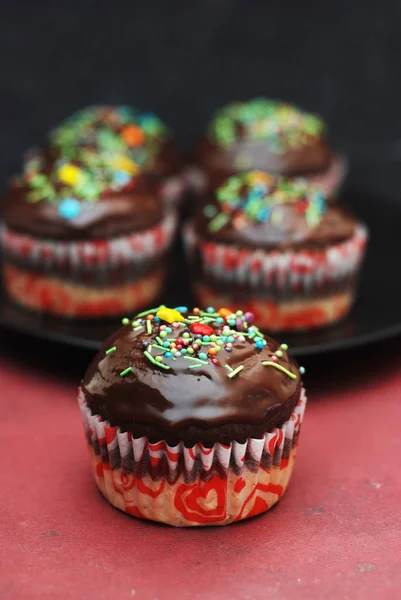 Muffins de chocolate caseiros para a Páscoa com Conffeti colorido. Fundo escuro. Sobremesa doce para café da manhã . — Fotografia de Stock