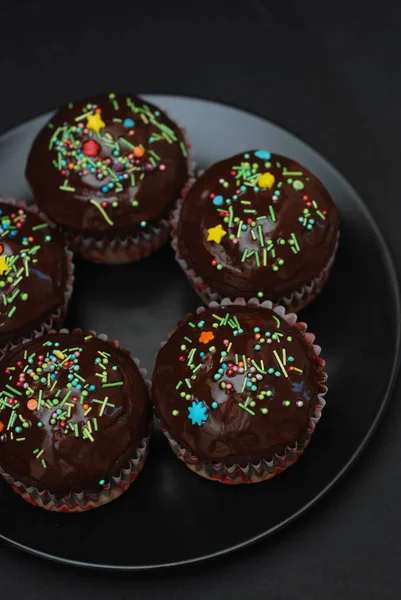 Hembakade chokladmuffins till påsk med färgade Conffeti. Mörk bakgrund. Söta Dessert för frukost. — Stockfoto