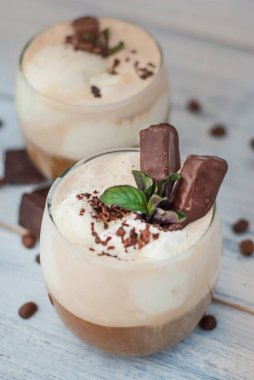 Buzlu Mocha kahve kırbaç krem, yaz kez içme. Kahve çekirdekleri. rustik ahşap arka plan dokulu. Nane yaprakları