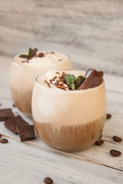 Buzlu Mocha kahve kırbaç krem, yaz kez içme. Kahve çekirdekleri. rustik ahşap arka plan dokulu. Nane yaprakları