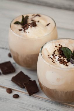 Buzlu Mocha kahve kırbaç krem, yaz kez içme. Kahve çekirdekleri. rustik ahşap arka plan dokulu. Nane yaprakları