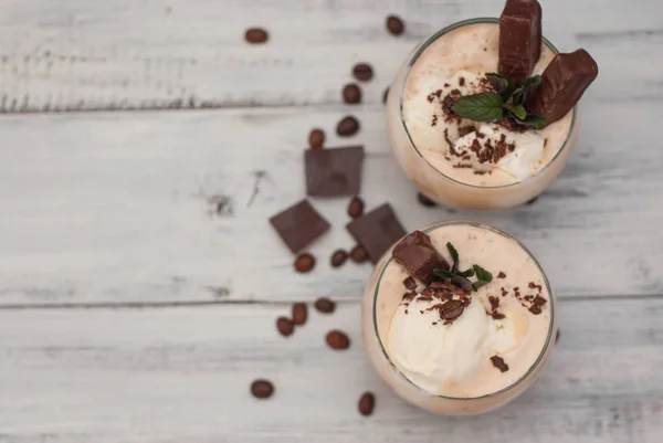 Iced Mocha Frappe Coffee with Whip Cream, Summer Drinking times. Coffee Beans. rustic textured Wooden Background. Mint Leaves Copy space — Stock Photo, Image