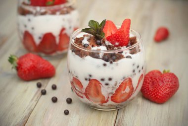 Cam beyaz Crea ile Çilekli pasta çilekli mans. Ev yapımı yaz tatlı beyaz rustik masada.