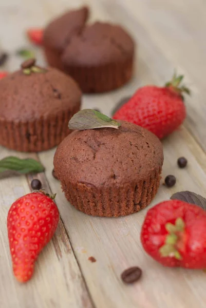 Čokoládové muffiny s jahodové lístky máty rustikální šedé pozadí snídani pouště — Stock fotografie