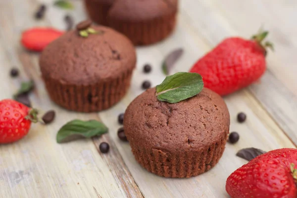 Čokoládové muffiny s jahodové lístky máty rustikální šedé pozadí snídani pouště — Stock fotografie