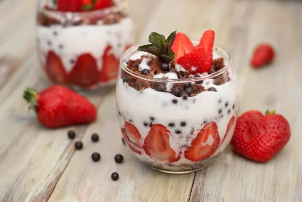 Cam beyaz Crea ile Çilekli pasta çilekli mans. Ev yapımı yaz tatlı beyaz rustik masada.