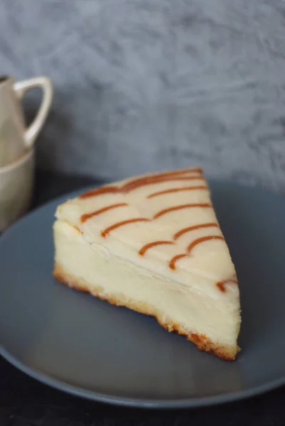 Torta di formaggio con salsa di caramello Salsa di caramello isolata su carta marrone con cucchiaio Dolce dessert di zucchero — Foto Stock