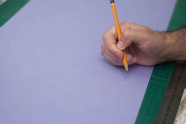 İnsan erkekler elini tutarak mor kağıt üzerinde basit bir kalem. Elini, kalem, Infographic, web, sunum, broşür için öğe gösteren resim.