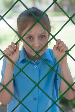 Üzgün kız parmaklıklar arkasında. Sad mevsimlik liseli kız parmaklıklar arkasında. Ebeveynlik, eğitim.