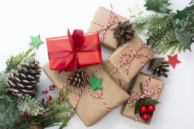 Hediye kutularıyla Noel süslemesi, şekillendirilmiş köknar dalı, çam kozalakları, beyaz arka planda çelenk. Kopyalama alanı olan üst görünüm.