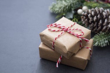 Noel arkaplanı hediye kutuları, köknar dalları ve kozalaklarla dolu. Kış tatili tebrik kartı.