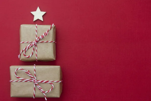 Řemeslné dárkové krabice přes červené pozadí. Vánoční maketa s kopírkou. zimní dovolená s dárky, výhled shora, byt ležel. — Stock fotografie
