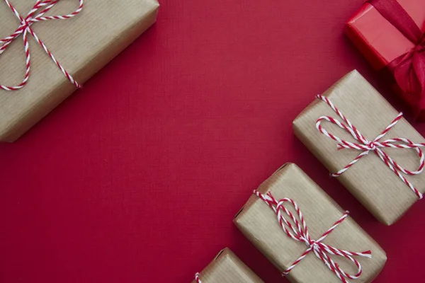 Jul röd bakgrund, mocka upp med hantverk papper presentförpackningar och kopiera utrymme. Vinter semester med presenter, ovanifrån, platt låg. — Stockfoto
