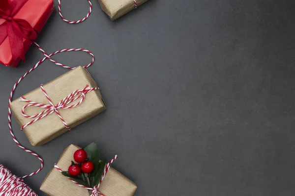 Řemeslné dárkové krabice na tmavém pozadí. Vánoční maketa s kopírovacím prostorem. Zimní dovolená s dárky, výhled shora, byt ležel. — Stock fotografie