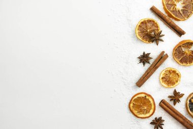 Noel kış baharatları. Tarçın çubukları, yıldız anason, beyaz arka planda izole edilmiş portakal dilimleri..
