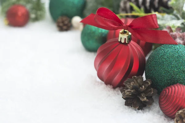 Bolas rojas de Navidad, adornos con cinta y ramas de abeto verde, conos de pino, sobre fondo blanco de nieve. Vacaciones de invierno. Tarjeta de felicitación abstracta de Navidad. Copiar espacio . — Foto de Stock