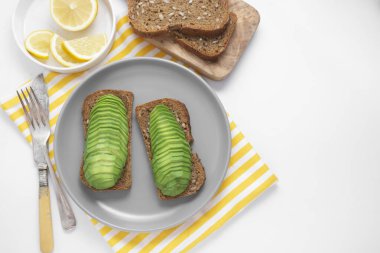 Tost ekmeğine dilimlenmiş avokado, sağlıklı kahvaltı. En iyi vejetaryen yemeği manzarası. Avokado, kızarmış ekmek..