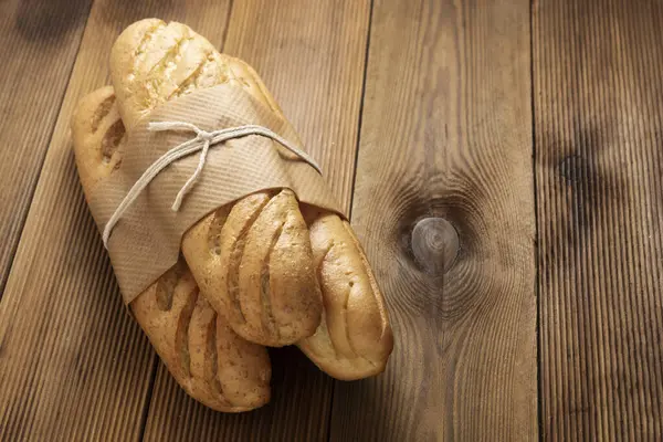 Pães de pão baguetes na mesa de madeira, estilo rústico. Pastelaria, café da manhã, pão para sanduíche isolado, espaço de cópia . — Fotografia de Stock