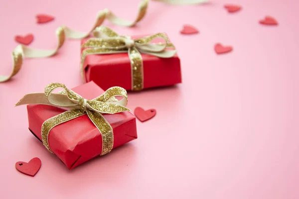ピンクの背景に赤いギフトボックスと黄金の弓。バレンタインデー誕生日パーティーのコンセプト. — ストック写真